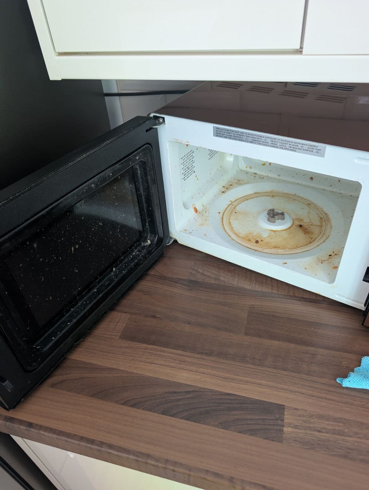 Microwave with food-splattered interior before cleaning